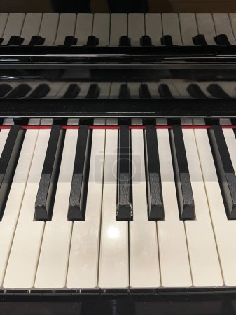 Téléchargez les photos : Vue de face d'un clavier piano avec son reflet sur le couvercle, octave musicale complète, échelle musicale, touches piano, verticale - en image libre de droit