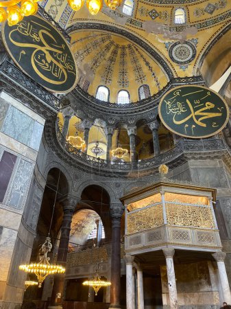 Téléchargez les photos : Deux boucliers avec inscriptions arabes avec noms de personnalités islamiques illustres et lampes suspendues à l'intérieur de la mosquée de sainte sofia à Istanbul, verticale - en image libre de droit