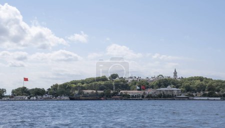 Photo for Panoramic view of the majestic Topkapi Palace seen from the Bosphorus from the Sea of Marmara with a Turkish flag waving, golden horn in Istanbul, Turkey, residence of the Ottoman Sultans horizontal - Royalty Free Image