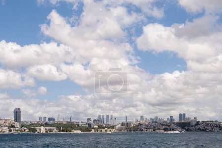 panoramic view of the skyline of the financial center of Istanbul seen from the Bosphorus, with the Dolmabahce palace under a cloudy sky, copy space, horizontal