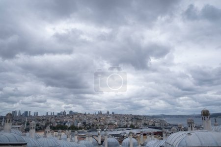 vista panorámica de la ciudad de Estambul desde el mirador de la mezquita de Suleiman, con sus techos típicos en primer plano, en un día nublado con ambiente tormentoso, espacio para copiar