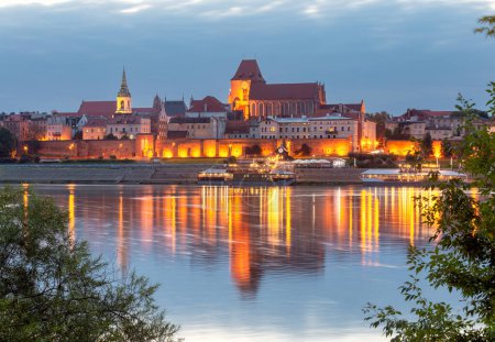 Der zentrale Damm der Stadt bei nächtlicher Beleuchtung und der Fluss bei Sonnenuntergang. Torun. Polen.
