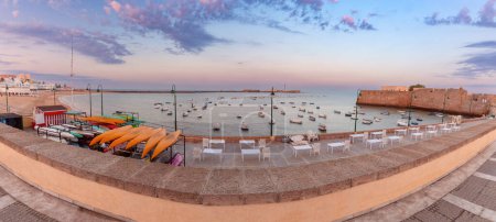 Téléchargez les photos : Vue panoramique pittoresque sur la plage et la baie de la ville avec des bateaux de pêche à l'aube. Cadix. Espagne. Andalousie. - en image libre de droit