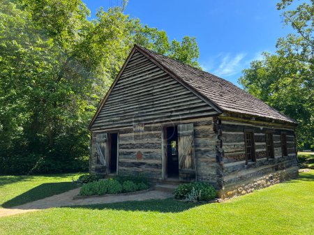 Historic Meeting House exterior in the recreated and restored 1800 Pioneer Village at Spring Mill State Park, near Mitchell, Indiana with beautiful blue sky copy space and vivid green trees and grass.
