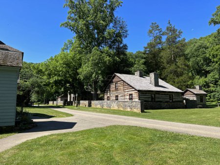 Histórica Residencia Inferior en el recreado y restaurado 1800 Pioneer Village en Spring Mill State Park, cerca de Mitchell, Indiana, con hermoso espacio para copiar el cielo azul y vívidos árboles verdes y hierba.
