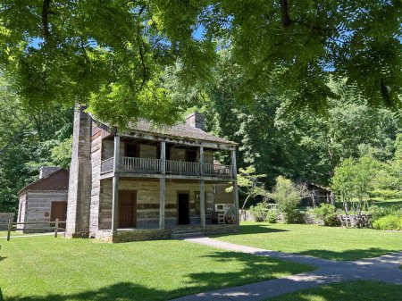 Foto de Histórica residencia superior en la recreada y restaurada 1800 Pioneer Village en Spring Mill State Park, cerca de Mitchell, Indiana, con hermoso cielo azul y espacio de copia de hierba verde. - Imagen libre de derechos