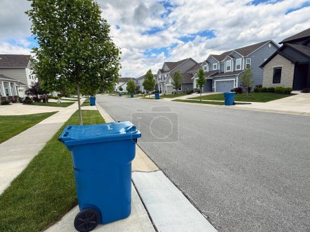 Blaue Mülltonnen säumen die Straße am Tag des Mülls in einem Viertel von Indiana mit Kopierraum.