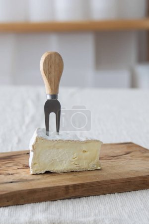 Photo for Piece of camamber brie cheese on wooden board. Selective focus - Royalty Free Image