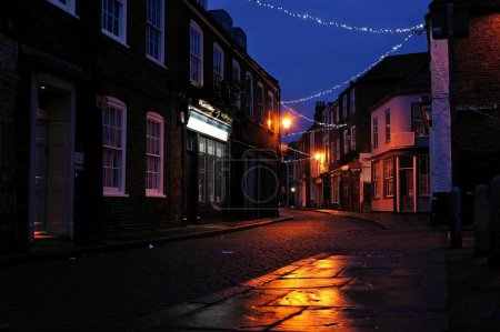 Foto de Calle victoriana vacía en una noche de invierno con alumbrado público de Navidad. - Imagen libre de derechos