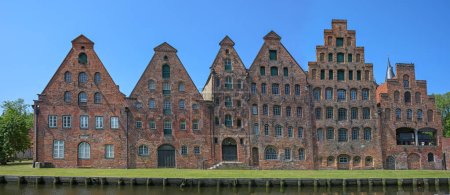 Lübecker Salzspeicher, historische Salzlagerhallen in roter Backsteinarchitektur vor blauem Himmel, Wahrzeichen und Ausflugsziel in der alten Hansestadt, Panoramaformat