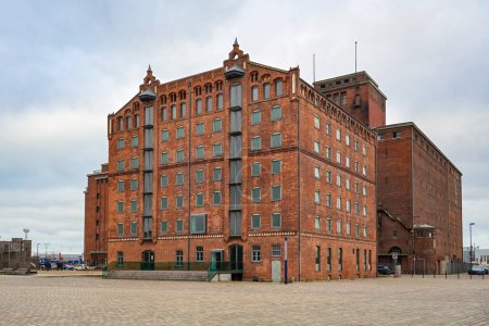 Thormann Speicher, historic granary building of red brick at the old harbor in Wismar, Germany, the heritage-listed landmark is now renovated for gastronomy and offices, gray overcast sky, copy space