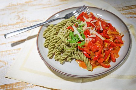 Healthy legume noodles made from mung beans with peppers and tomato vegetables on a light plate, cooking vegan with lots of protein, vitamins and dietary minerals, copy space, selected focus
