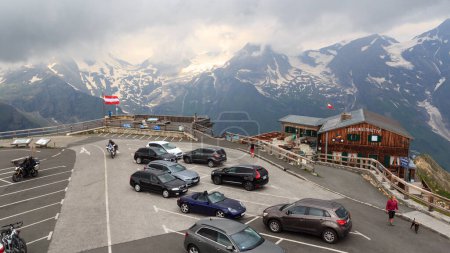 Photo for Fusch, Austria - July 25, 2021: Parking lot with cars, mountain panorama and alpine hut Edelweisshuette on Edelweissspitze at Grossglockner High Alpine Road. - Royalty Free Image