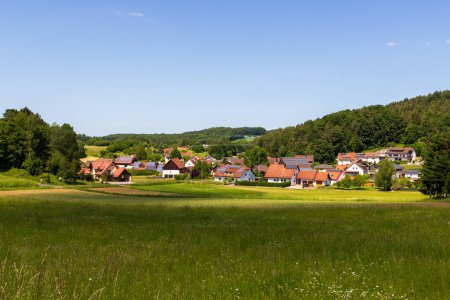 Rural scene with hill panorama, meadows and houses of village Baernfels near Obertrubach in Franconian Switzerland, Germany