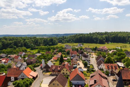 Ländliche Szenerie mit Hügellandschaft, Wiesen und Häusern des Dorfes Wichsenstein in der Fränkischen Schweiz