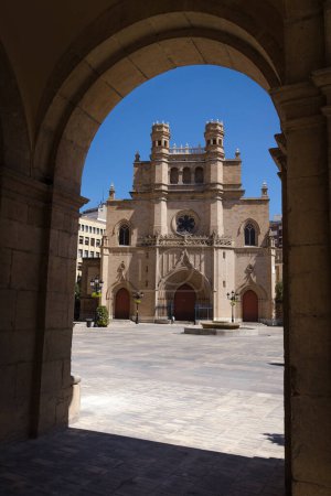 Foto de Main square of Castellon de la Plana through an arch with the Co-Cathedral of Santa Maria in the background on a sunny day with a blue sky, Spain - Imagen libre de derechos