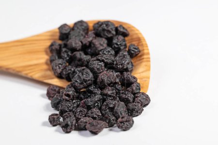Dried blueberries on a wooden spoon