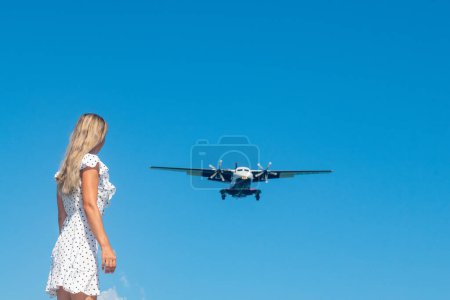 Photo for Whispering Waves: A Girl in White Meets a Plane by the Blue Sea. High quality photo - Royalty Free Image