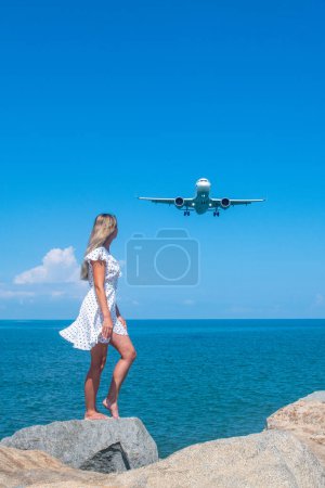 Photo for Synchronizing Dreams: Girl in White Meets a Plane Above the Blue Sea. High quality photo - Royalty Free Image