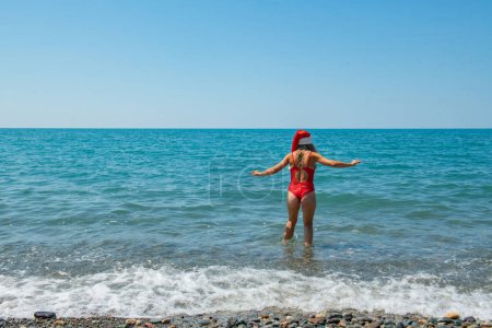 Photo for Tropical Santa Splash: Red Swimsuit by the Sea. High quality photo - Royalty Free Image