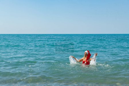 Photo for Tropical Christmas Splash: Red Swimsuit and Santa Hat. High quality photo - Royalty Free Image