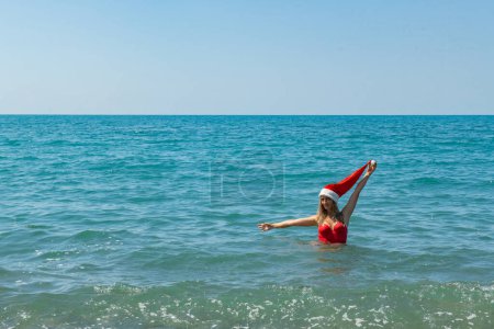 Photo for Sun-Kissed Santa: Girl in Red Swimsuit Diving. High quality photo - Royalty Free Image