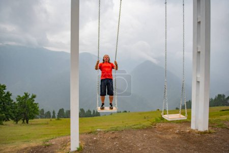 Gravity-Defying Delight: Man Hanging Loose in Orange T-Shirt. High quality photo