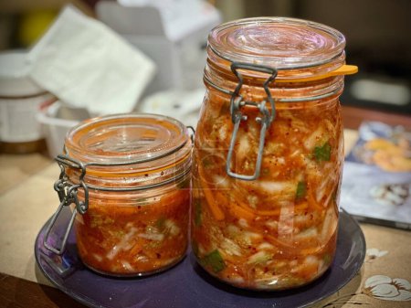 Téléchargez les photos : Kimchi fait maison dans des bocaux en verre scellé sur comptoir de cuisine - en image libre de droit
