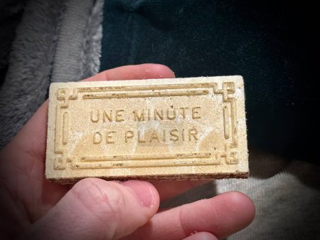 Photo pour "Une minute de plaisir "- Tenir un biscuit délicatement inscrit avec un message français invitant - image libre de droit