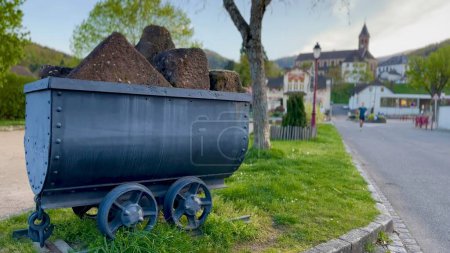 Vida de pueblo vibrante en Buhl con carro histórico de la cantera de arenisca, Alsacia, Francia, con el hombre corriendo en el fondo