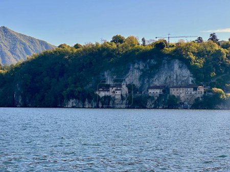 Nahaufnahme der historischen Eremitage von Santa Caterina del Sasso, die auf den felsigen Klippen über dem Lago Maggiore thront