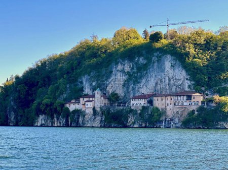 Detailed View of Santa Caterina del Sasso Hermitage Nestled Against Rocky Cliffs Overlooking the Calm Waters of Lake Maggiore