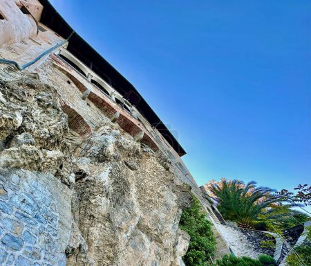 Blick nach oben auf die Klippenarchitektur der Santa Caterina del Sasso Eremitage bei klarem blauem Himmel