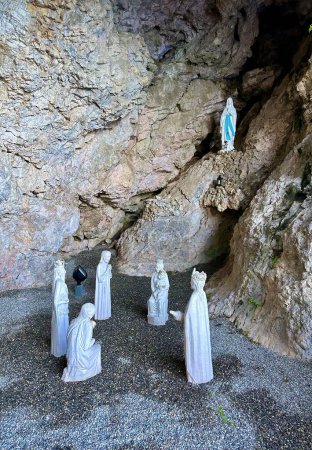 Outdoor Nativity Scene with Mary and the Wise Men Statues Set Against a Natural Rocky Cave Background
