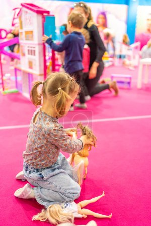 Photo for Prague, Czech Republic - April 27, 2023: Little girl playing in childrens playroom with Barbie toys and Hot Wheels in the Letnany shopping center in Prague, Czech Republic. High quality photo - Royalty Free Image