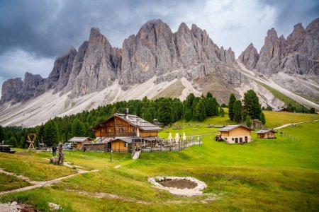 Téléchargez les photos : Impressionnant paysage Dolomite dans le parc naturel de Puez Odle - vue depuis le plateau alpin avec des maisons en bois et des prairies verdoyantes. Photo de haute qualité - en image libre de droit