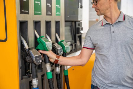 Homme tenant une buse d'essence dans sa main sur la station-service libre-service, mais se concentrer sur le diesel moins cher en Europe. Photo de haute qualité