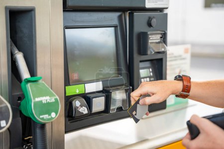Vue rapprochée de l'homme main paie pour le carburant avec une carte de crédit sur le terminal de la station-service libre-service en Europe. Photo de haute qualité