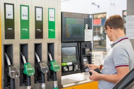 L'homme paie le carburant avec une carte de crédit sur le terminal de la station-service libre-service en Europe. Photo de haute qualité