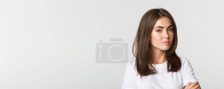 Photo for Close-up of attractive brunette girl looking skeptical and unamused. - Royalty Free Image