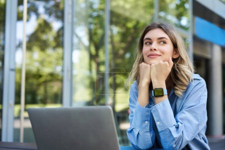Photo for Portrait of young corporate woman working outdoors. Freelancer smiling, sitting with laptop outside. Businesswoman sitting outdoors with computer. - Royalty Free Image
