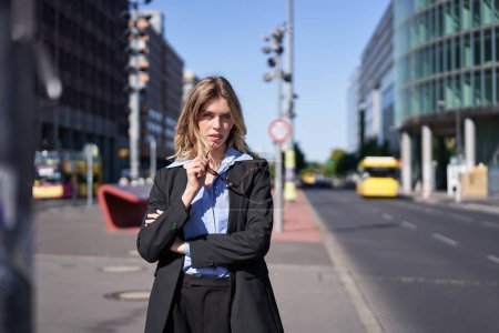 Photo for Portrait of confident business woman in suit, cross arms on chest, looking self-assured in city center, standing on street. Corporate people - Royalty Free Image