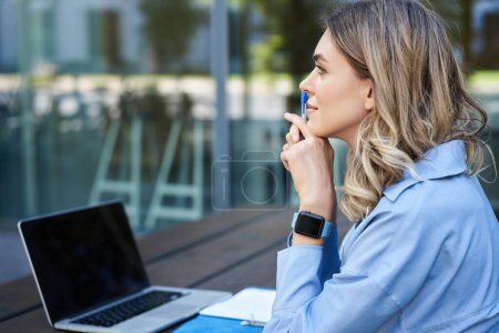 Photo for Close up portrait of woman student attend online course classes, sitting outside on fresh air with laptop and taking notes. Businesswoman video chat on computer. - Royalty Free Image
