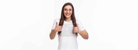 Photo for Good idea, lets do it. Enthusiastic smiling caucasian woman in glasses, fully support your plan, show thumbs-up and nod in approval, grinning positive reply, like and encourage keep going. - Royalty Free Image