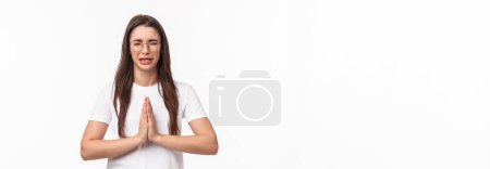 Photo for Waist-up portrait of desperate, hopeful young cute girl, sobbing and crying while praying, begging for mercy, ask something from person, feeling distressed, standing white background. - Royalty Free Image