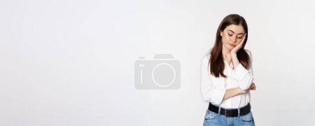 Photo for Unamused, bored brunette woman looking gloomy and sad, sighing, standing reluctant over white background. - Royalty Free Image