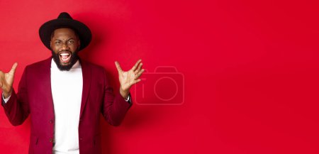 Photo for Angry Black man screaming and shaking hands with hatred, losing temper, standing outraged against red background. - Royalty Free Image