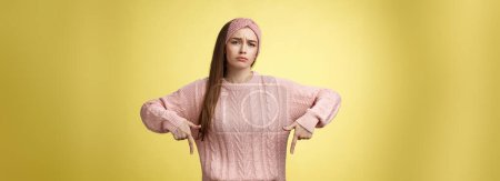 Photo for Why me, gosh. Gloomy upset complaining cute glamout young european girl in casual sweater, headband frowning, whining grimacing displeased pointing down, unhappy see lots work over yellow wall. - Royalty Free Image