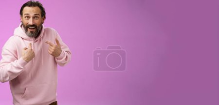 Téléchargez les photos : Excité surprié caucasien barbu gars pointant lui-même étonné interrogé ne peut pas croire a été choisi debout excité fond violet devenir gagnant de loterie à capuche rose. - en image libre de droit