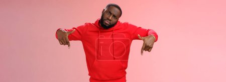 Photo for Cheeky stylish good-looking black bearded guy look cool tilting head bossy confident frowning seriously pointing down showing awesome place hang out homies, standing pink background. - Royalty Free Image